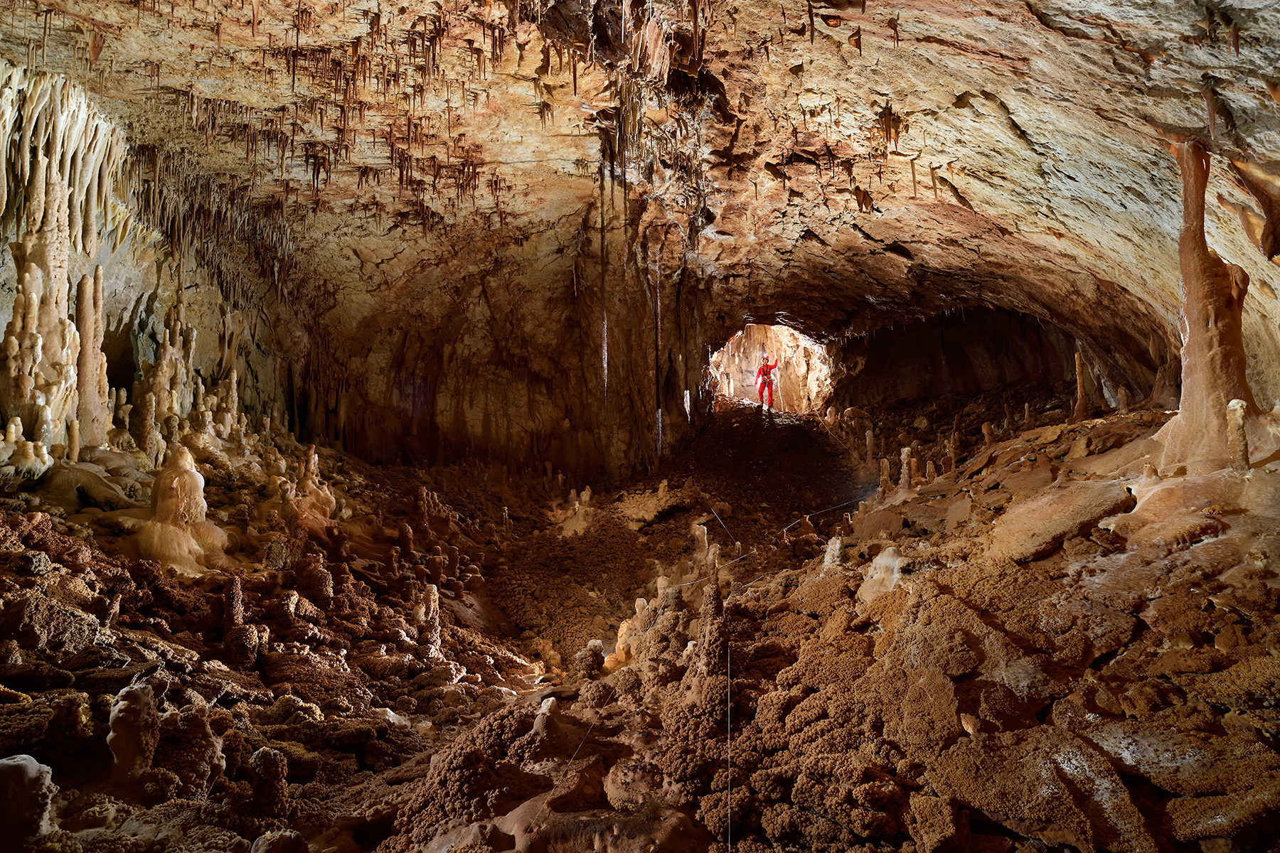 Grotte Emeraude (Gard) - Première salle (le spéléo dans le fond est à la base du petit puits d'entré). Un balisage a été mis en place pour éviter les dégradations compte tenu des cristallisations recouvrant le sol